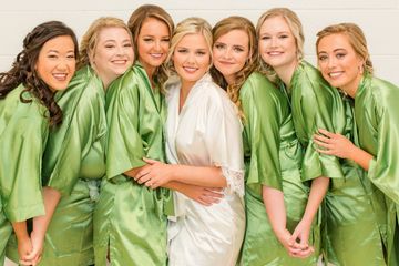 Bride and bridesmaids in matching green robes on the wedding morning